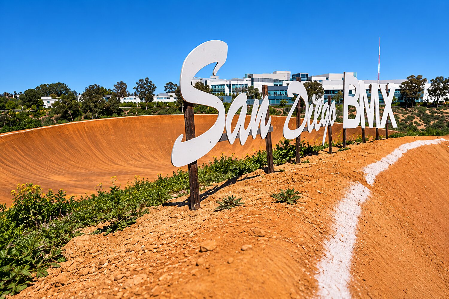The painted San Diego BMX wall beside the berm at the Kearny Mesa track